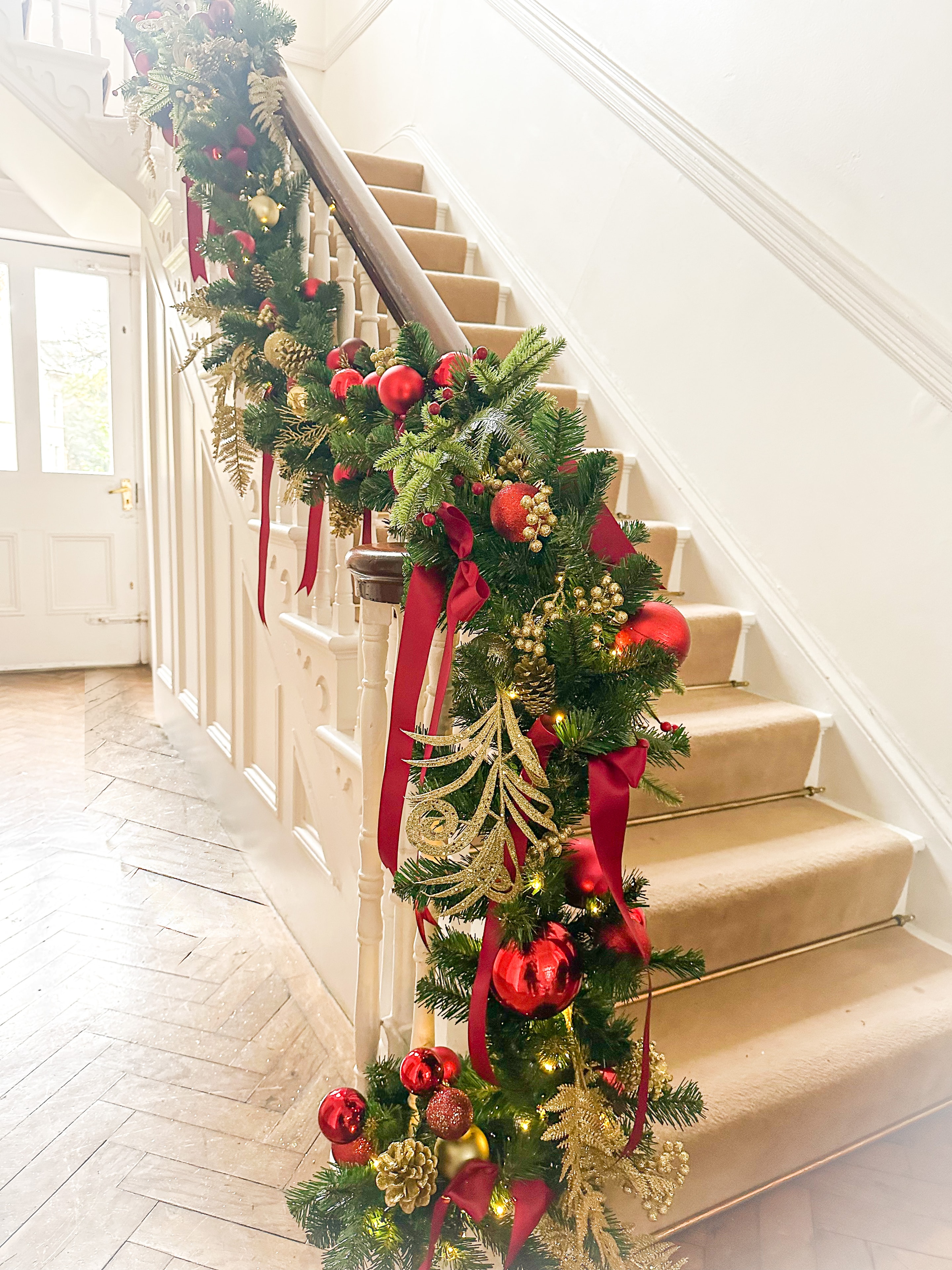 Classic staircase garland with red baubles and gold ribbon