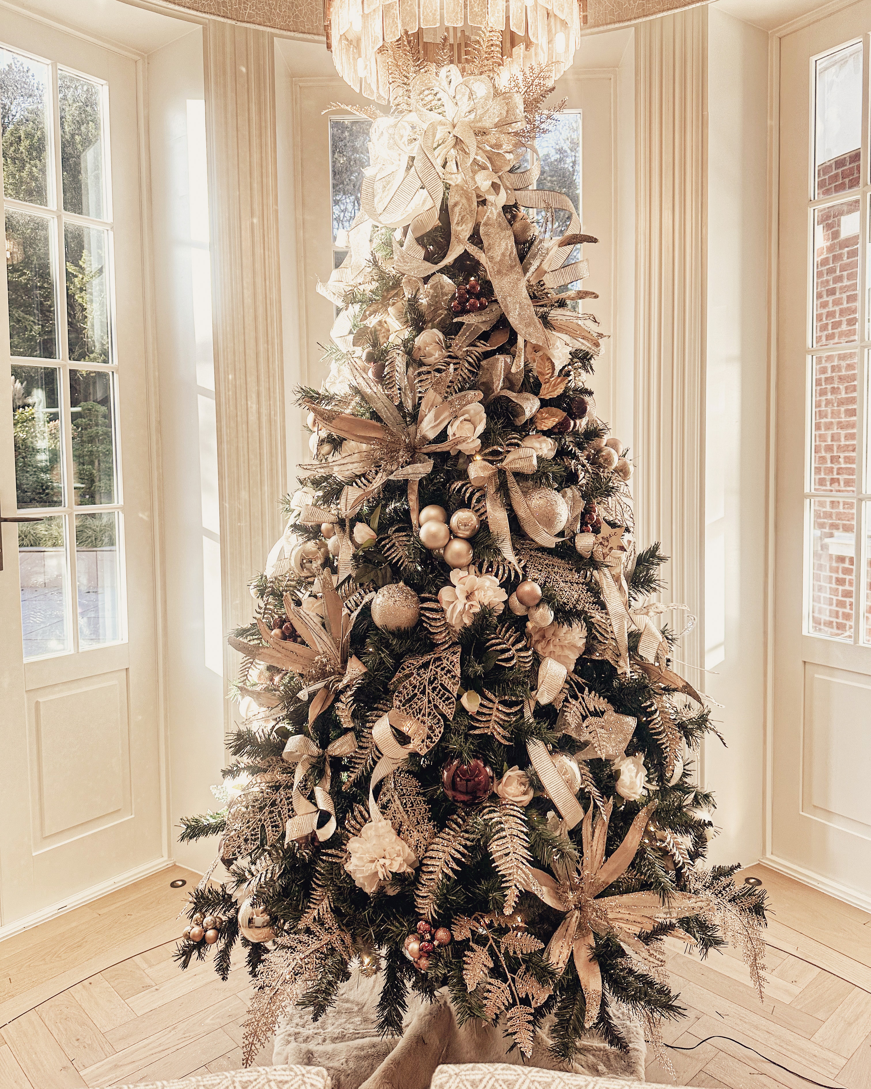 Luxury Christmas tree with champagne and gold ribbon in elegant room