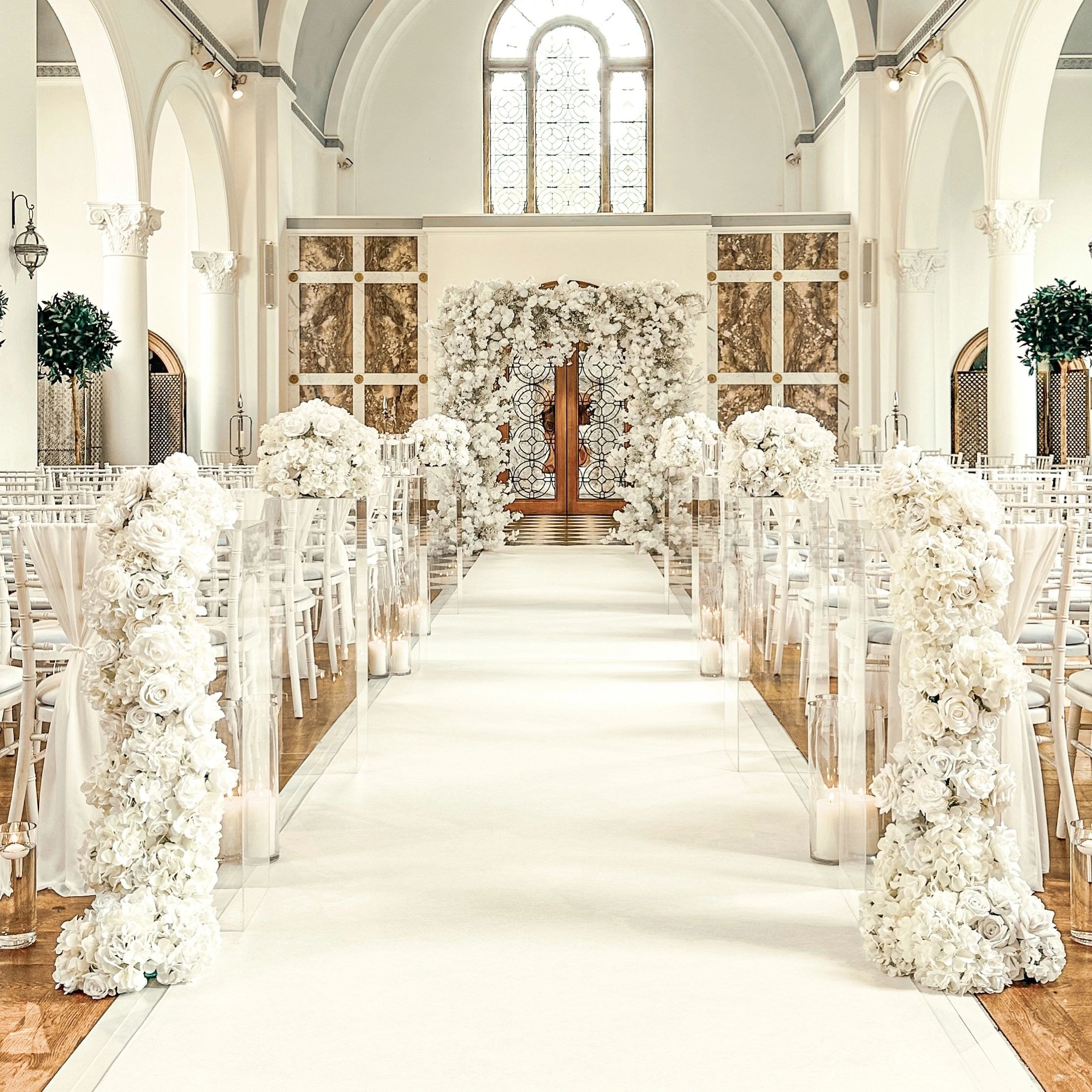 Grand white floral ceremony arch in classical venue