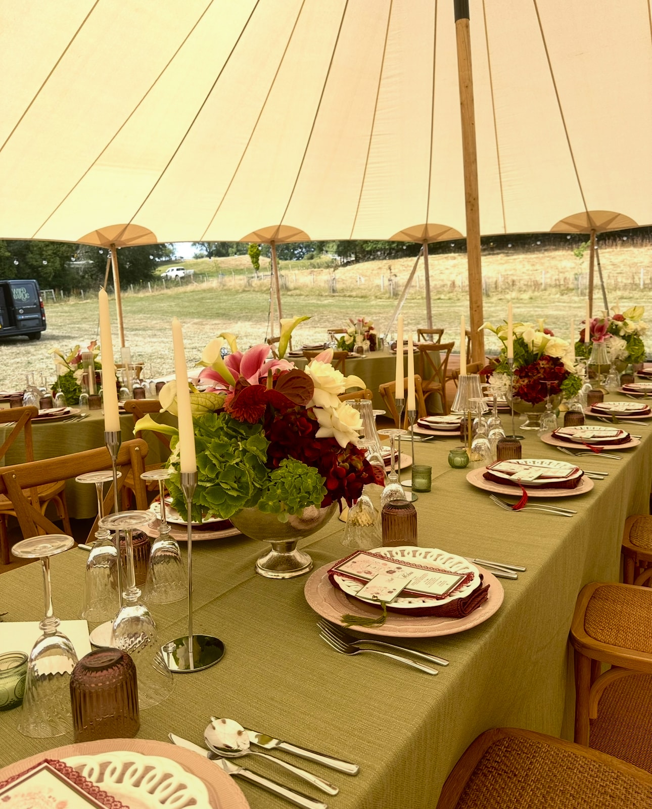 Tipi wedding reception with olive green linens and burgundy floral centrepieces