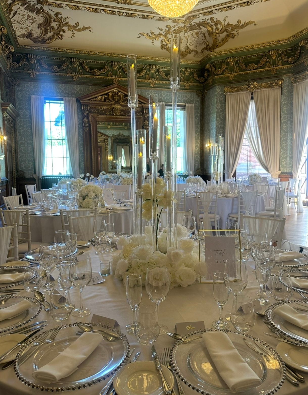 Grand ballroom with tall acrylic candelabra and white floral centrepieces