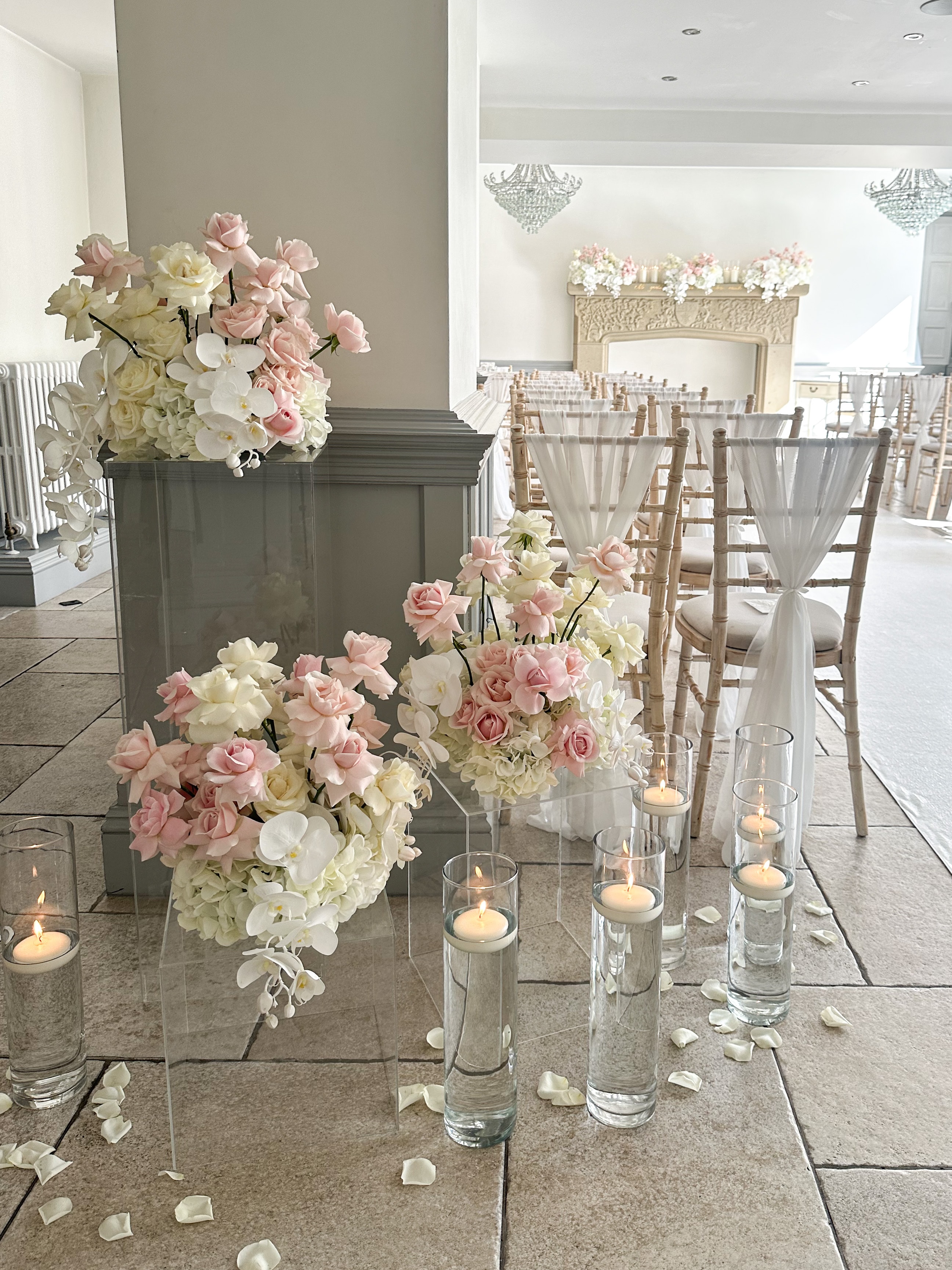 Elegant ceremony room with pink roses orchids acrylic stands and floating candles